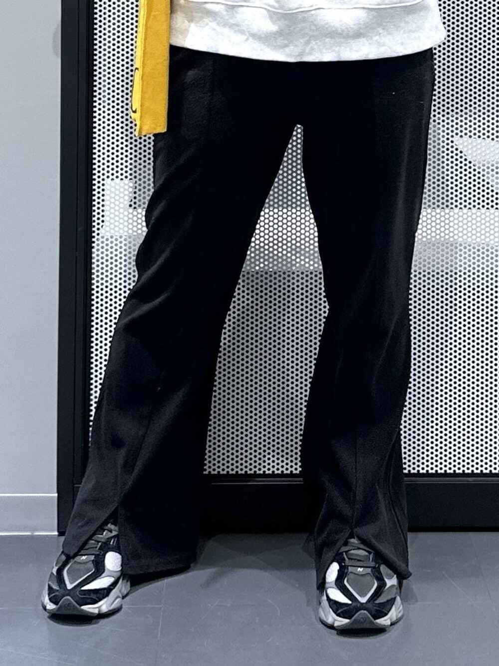 イエロー系のトートバッグ、ブラック系のダウンジャケット/コート、ブラック系のその他パンツを着用したレディースの冬コーディネートの7枚目の写真