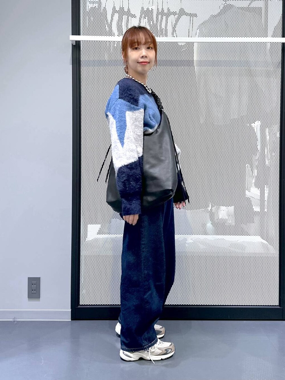 ブラウン系のスニーカー、ホワイト系のTシャツ/カットソー、ブルー系のデニムパンツを着用したレディースの冬コーディネートの3枚目の写真