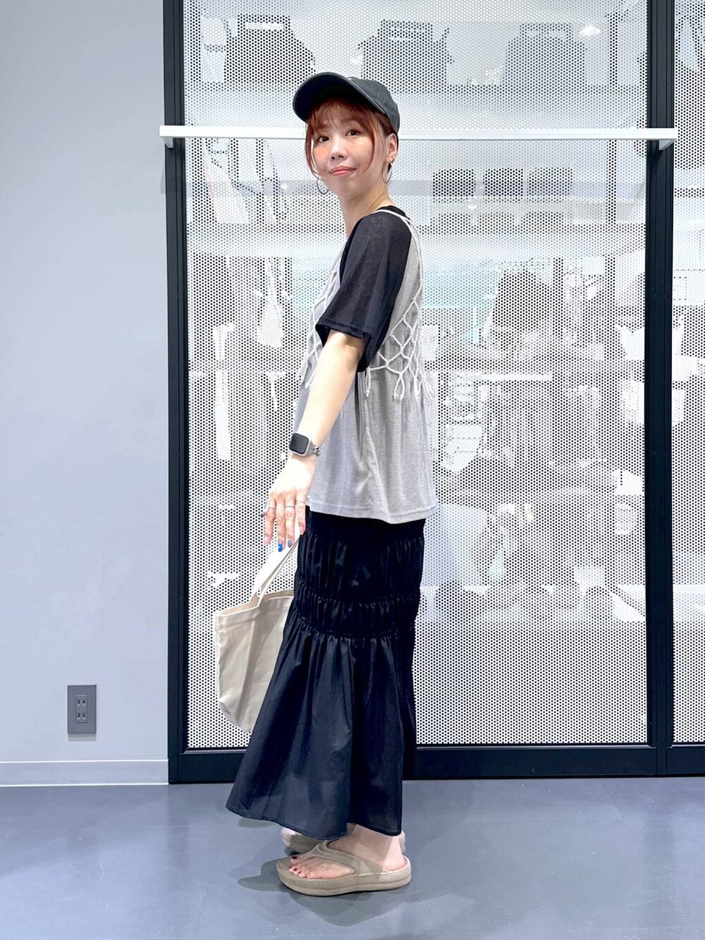 ホワイト系のベスト、ブラック系のスカート、その他のエコバッグ/サブバッグを着用したレディースの夏コーディネートの3枚目の写真