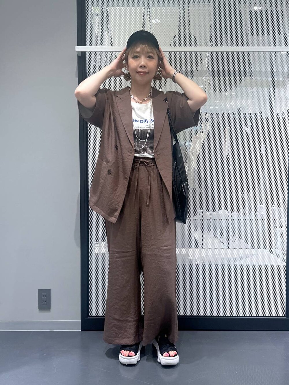 ブラック系のトートバッグ、ブラウン系のテーラードジャケット、ブラウン系のその他パンツを着用したレディースの春コーディネートの6枚目の写真