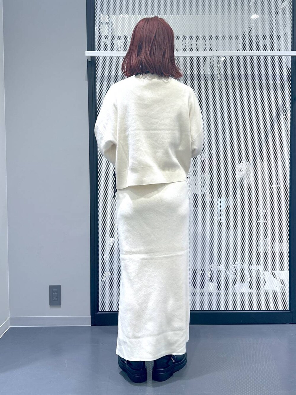 ブラック系のブーツ、ブラック系のハンドバッグ、ベージュ系のスカートを着用したレディースの秋コーディネートの4枚目の写真