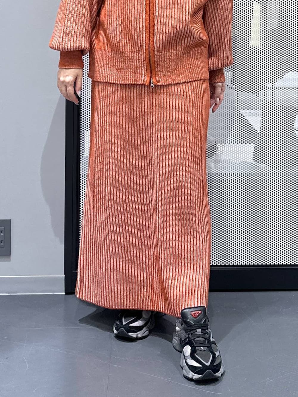 オレンジ系のスカート、オレンジ系のニット/セーター、その他のピアス（両耳用）を着用したレディースの冬コーディネートの5枚目の写真