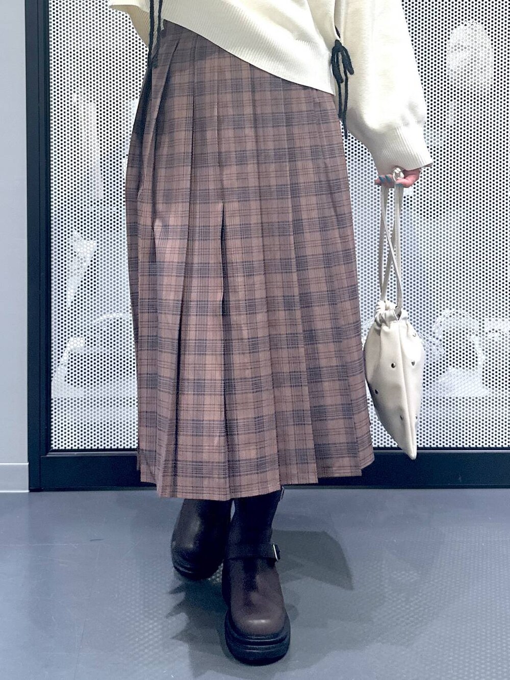 ホワイト系のショルダーバッグ、ブラック系のブルゾン、ブラウン系のブーツを着用したレディースの秋コーディネートの8枚目の写真