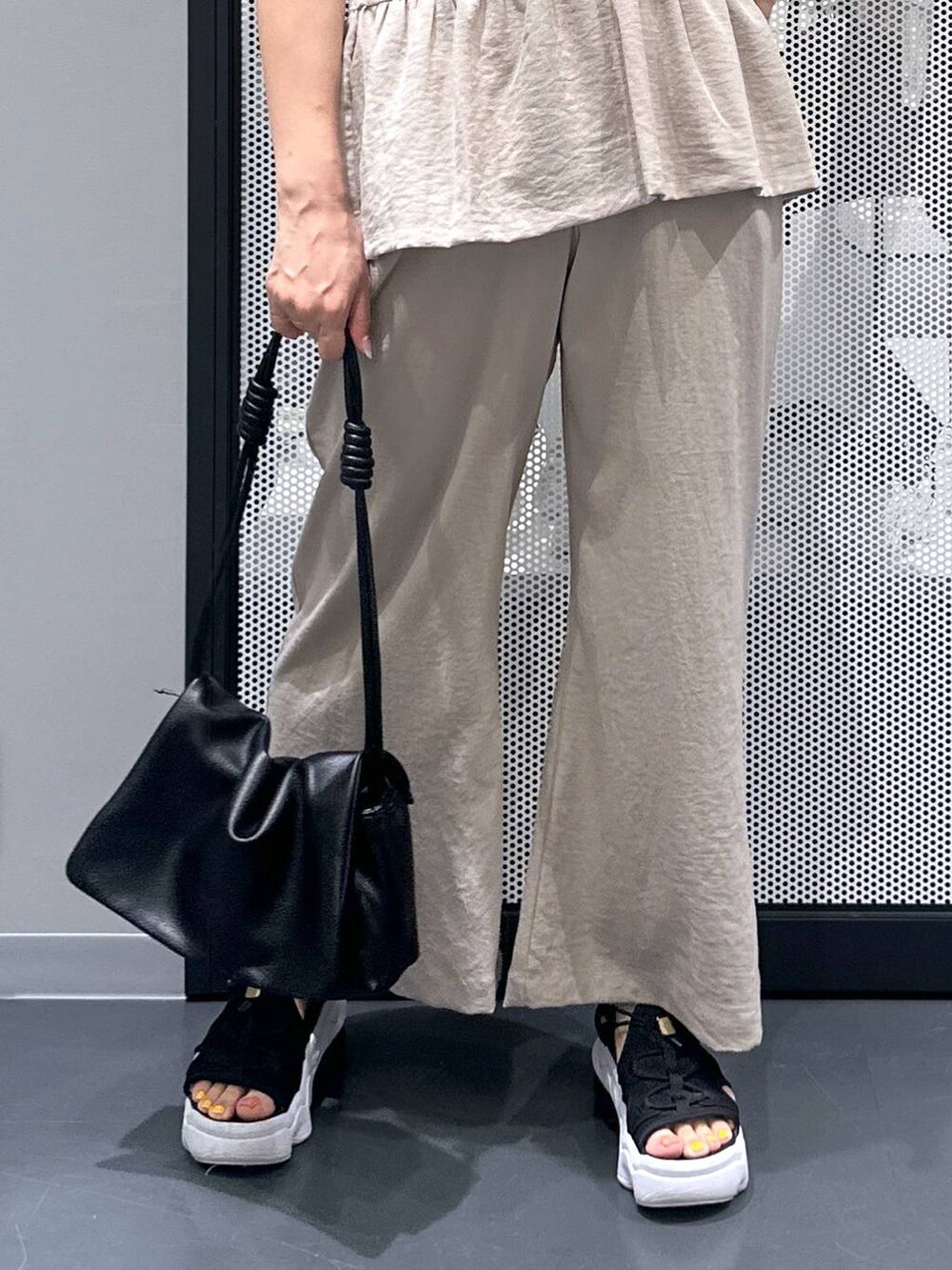 ブラック系のショルダーバッグ、ベージュ系のその他パンツ、ベージュ系のベストを着用したレディースの夏コーディネートの5枚目の写真