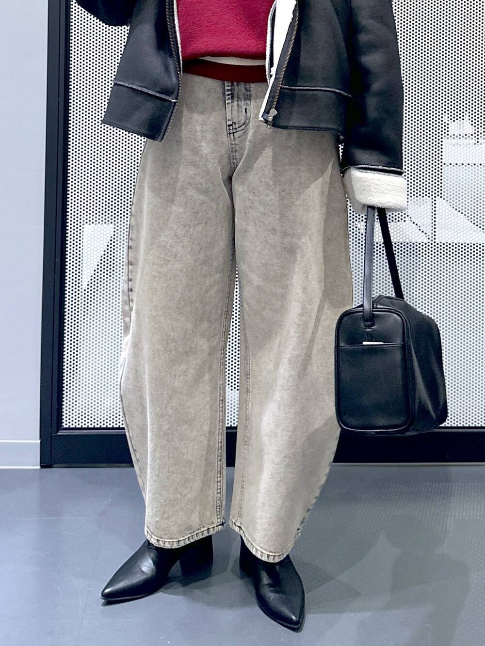 ブラック系のショルダーバッグ、ブラック系のブルゾン、ベージュ系のデニムパンツを着用したレディースの秋コーディネートの8枚目の写真