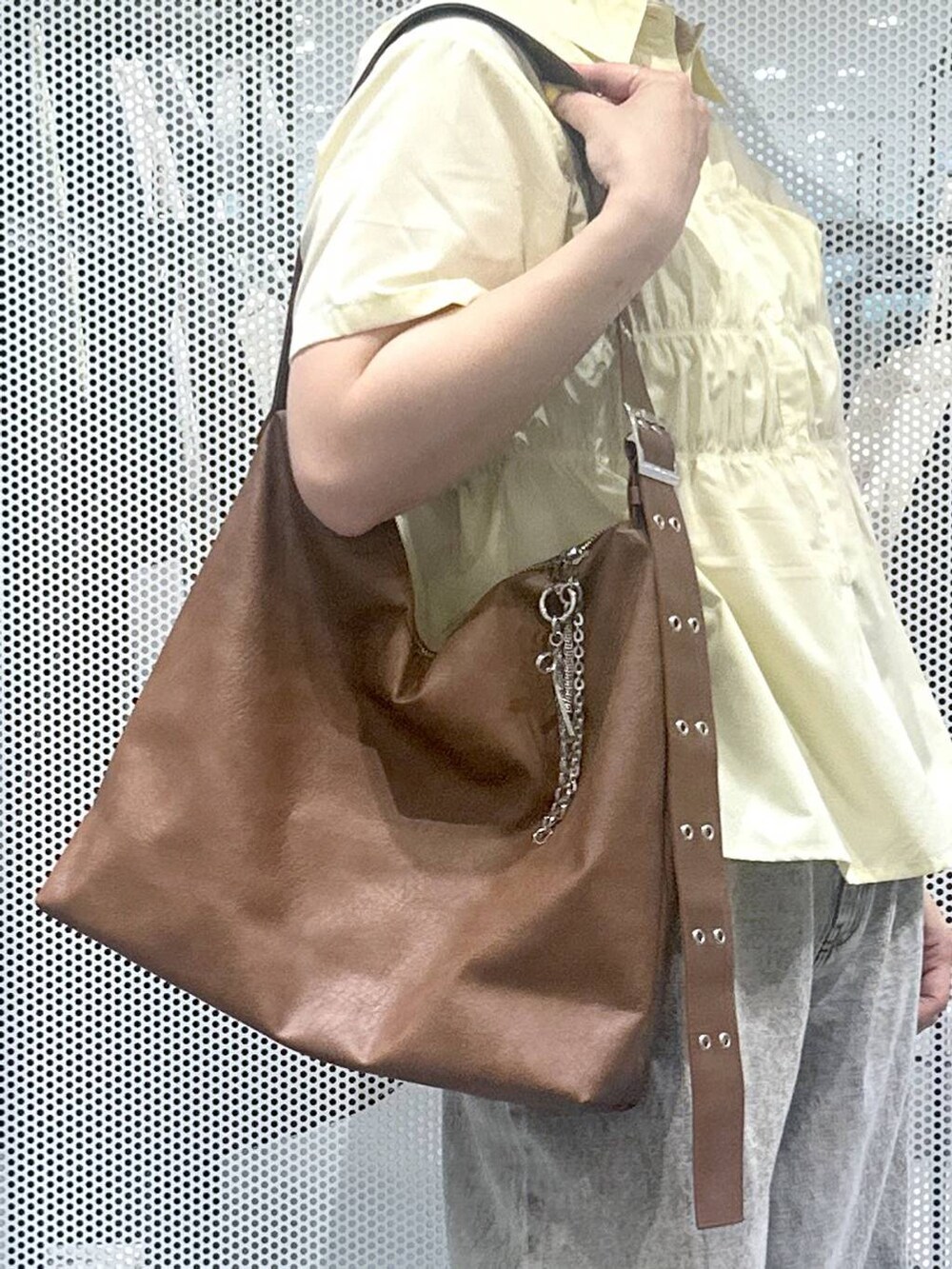 グレー系のデニムパンツ、ブラウン系のショルダーバッグ、イエロー系のシャツ/ブラウスを着用したレディースの夏コーディネートの4枚目の写真