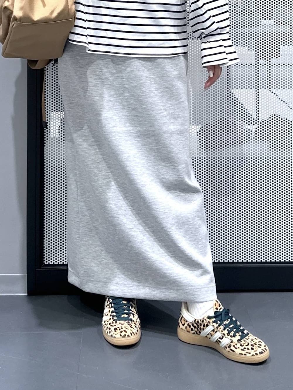 ベージュ系のその他シューズ、ベージュ系のバックパック/リュック、グレー系のスカートを着用したレディースの春コーディネートの5枚目の写真