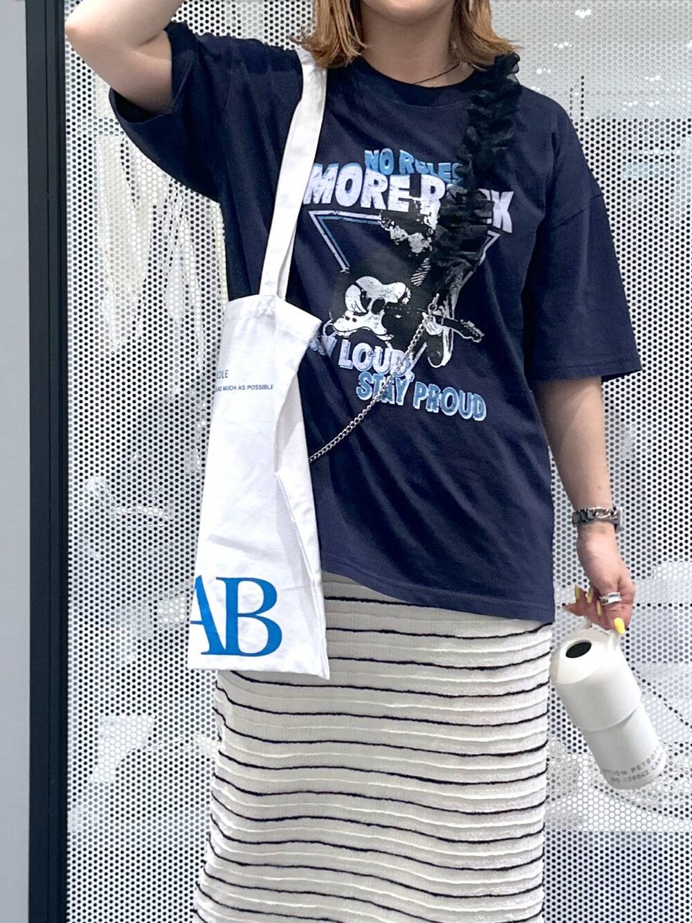 ホワイト系のトートバッグ、ホワイト系のスカート、ブルー系のTシャツ/カットソーを着用したレディースの春コーディネートの3枚目の写真