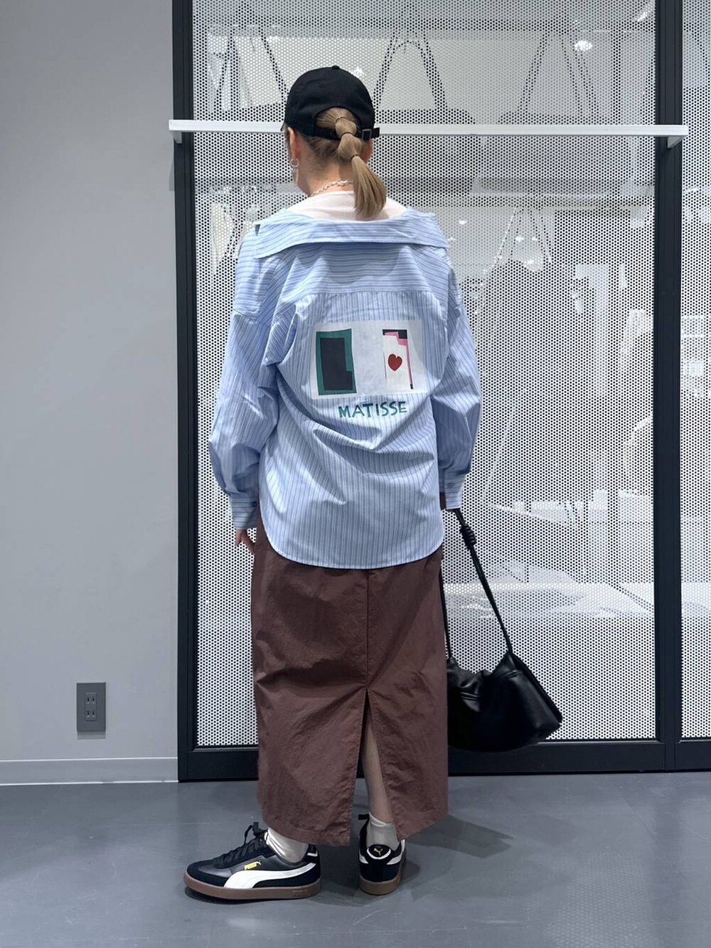 ホワイト系のTシャツ/カットソー、ブラック系のスニーカー、ブラック系のショルダーバッグを着用したレディースの秋コーディネートの3枚目の写真