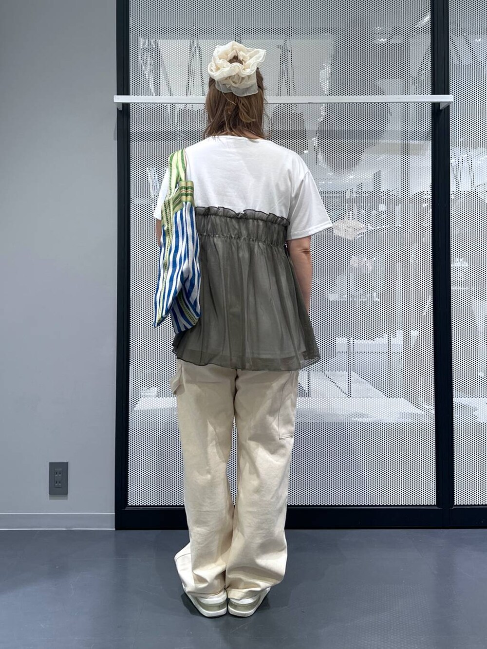 ブルー系のトートバッグ、グリーン系のTシャツ/カットソー、その他のピアス（両耳用）を着用したレディースの夏コーディネートの3枚目の写真