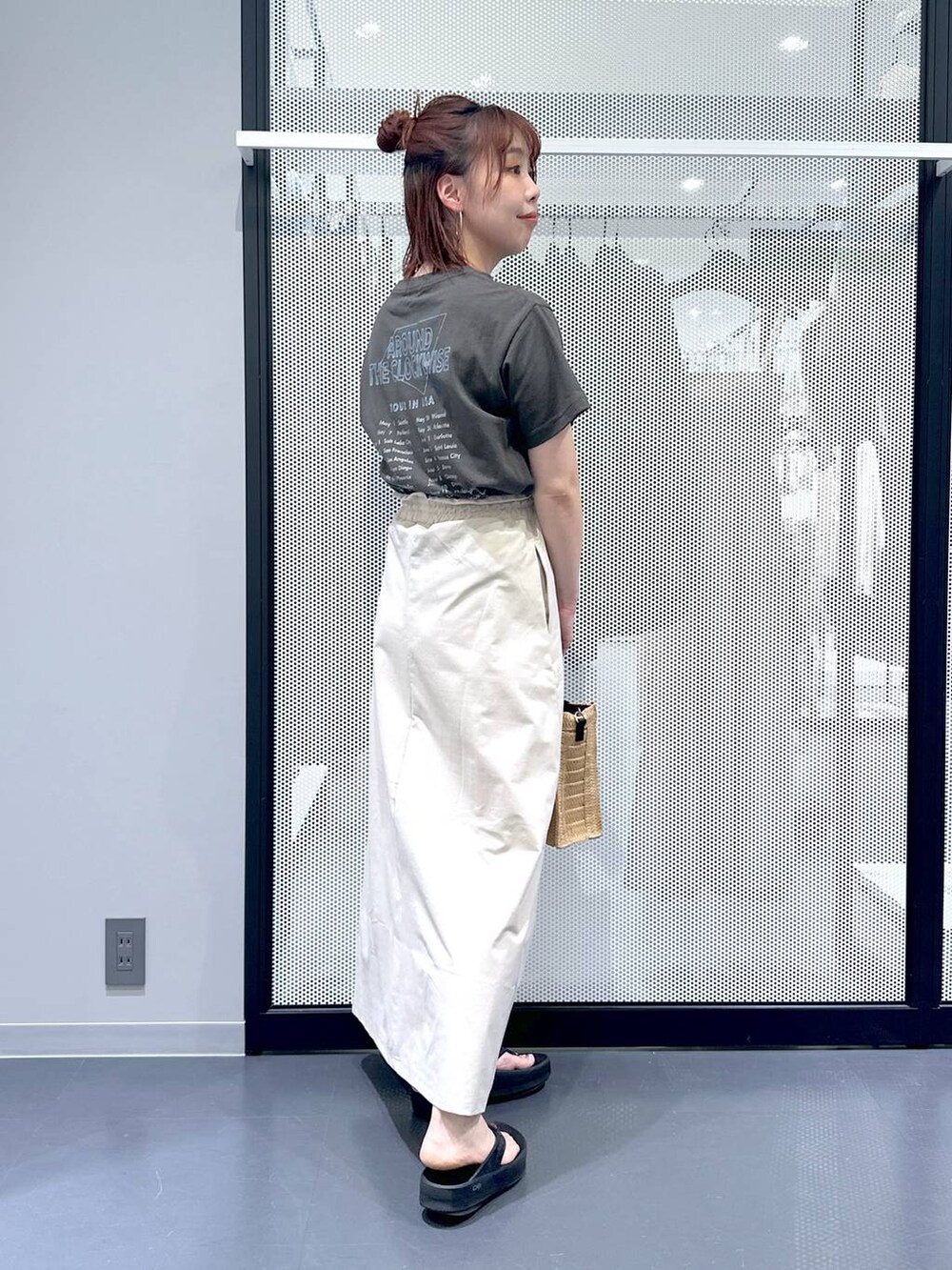 ベージュ系のスカート、ブラック系のサンダル、ベージュ系のショルダーバッグを着用したレディースの夏コーディネートの2枚目の写真