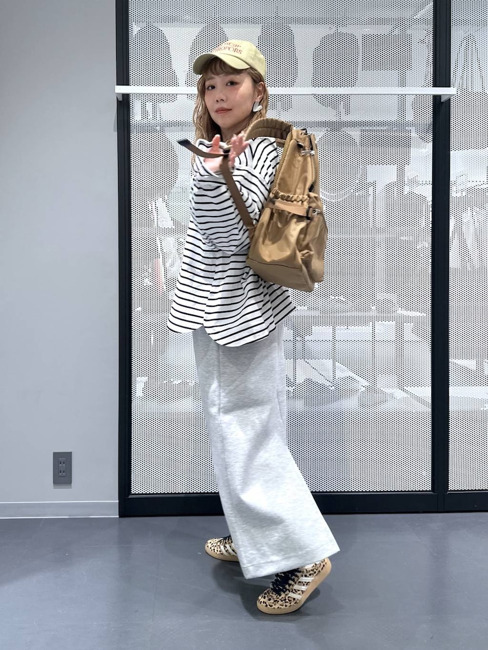 ベージュ系のその他シューズ、ベージュ系のバックパック/リュック、グレー系のスカートを着用したレディースの春コーディネートの7枚目の写真