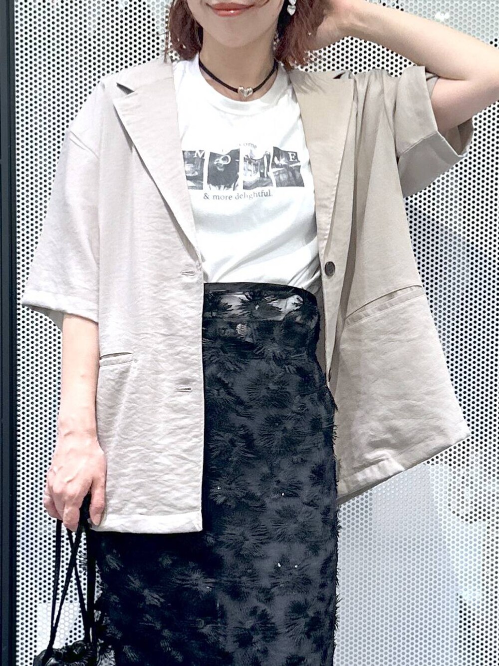 ブラック系のショルダーバッグ、ブラック系のデニムパンツ、ホワイト系のTシャツ/カットソーを着用したレディースの夏コーディネートの5枚目の写真