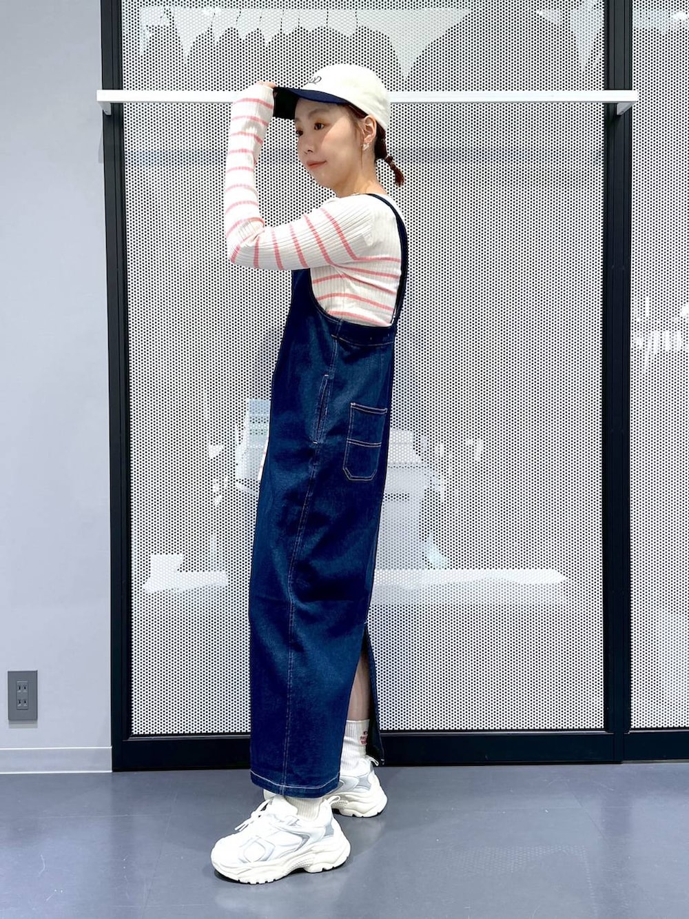 ブルー系のジャンパースカート、ベージュ系のMA-1、ピンク系のニット/セーターを着用したレディースの春コーディネートの4枚目の写真