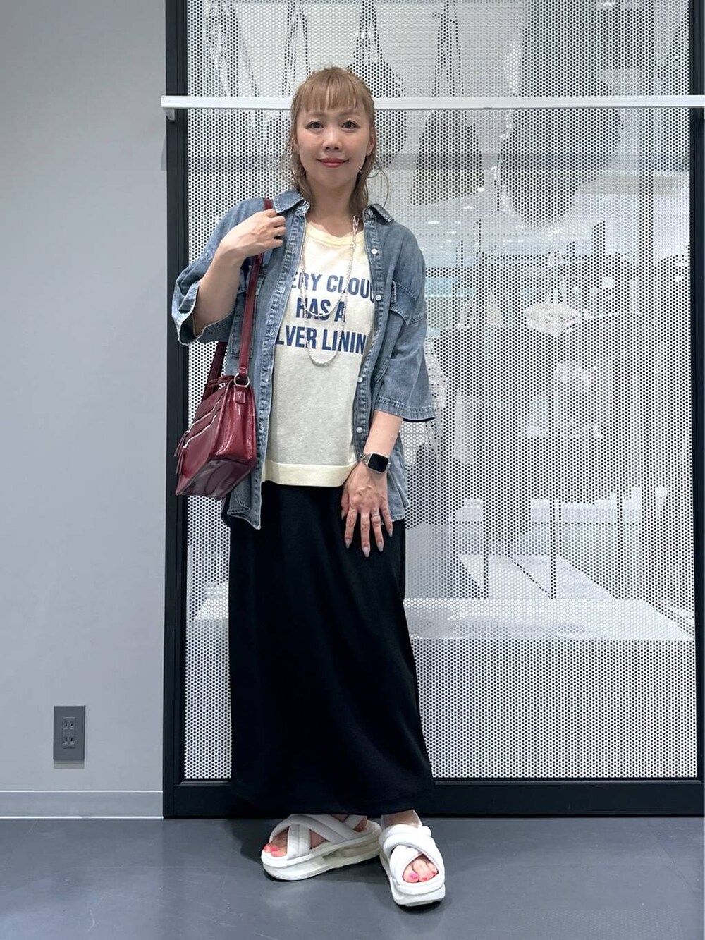 ブラック系のスカート、ブルー系のシャツ/ブラウス、レッド系のショルダーバッグを着用したレディースの夏コーディネートの2枚目の写真