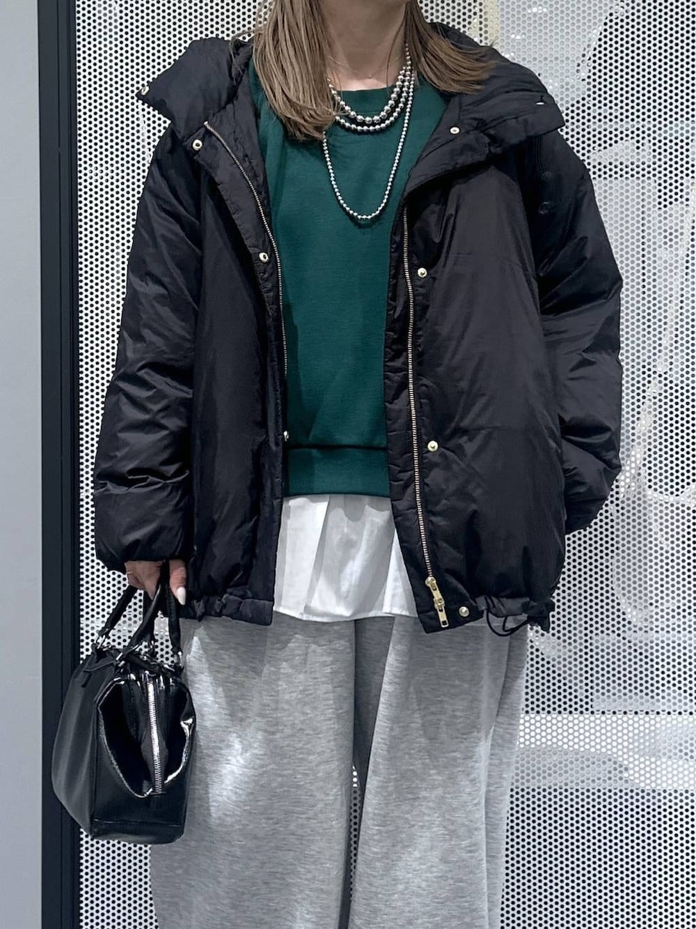 ブラック系のダウンジャケット/コート、ブラック系のショルダーバッグ、グレー系のスウェットパンツを着用したレディースの冬コーディネートの4枚目の写真