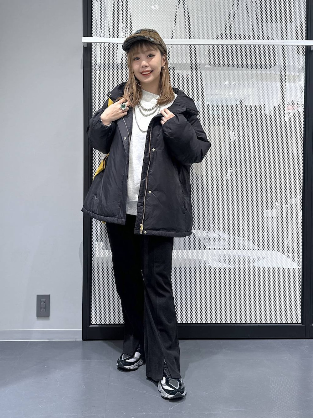 イエロー系のトートバッグ、ブラック系のダウンジャケット/コート、ブラック系のその他パンツを着用したレディースの冬コーディネートの3枚目の写真