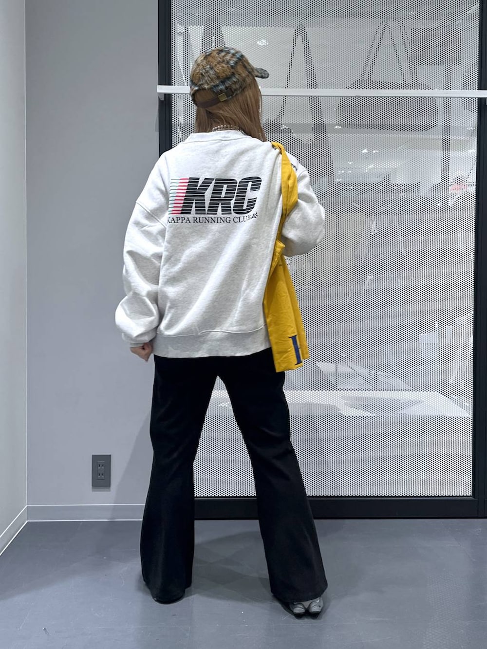 イエロー系のトートバッグ、ブラック系のダウンジャケット/コート、ブラック系のその他パンツを着用したレディースの冬コーディネートの4枚目の写真