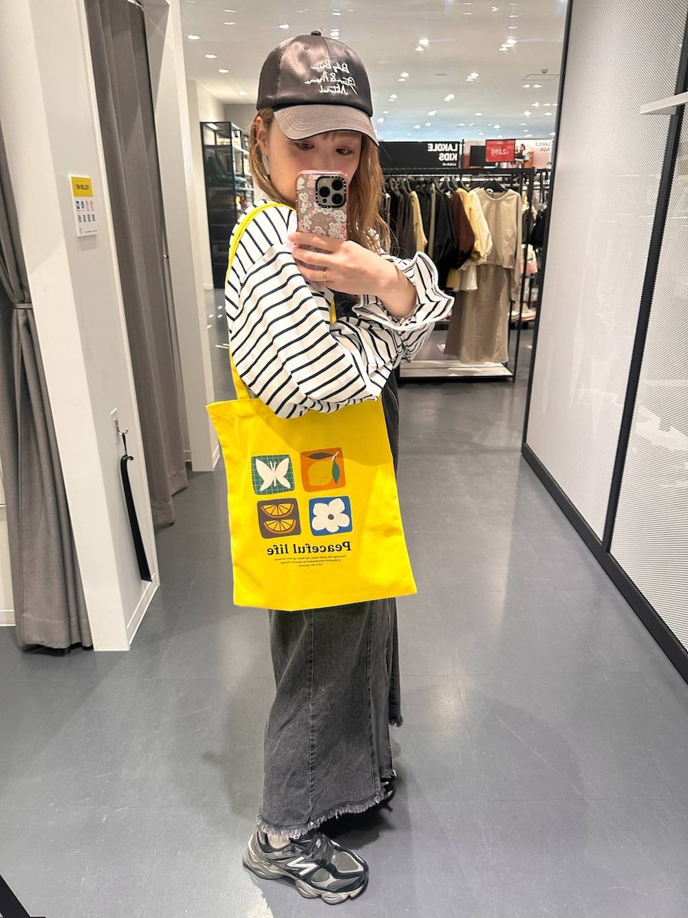 イエロー系のトートバッグ、その他のピアス（両耳用）を着用したレディースの春コーディネートの5枚目の写真