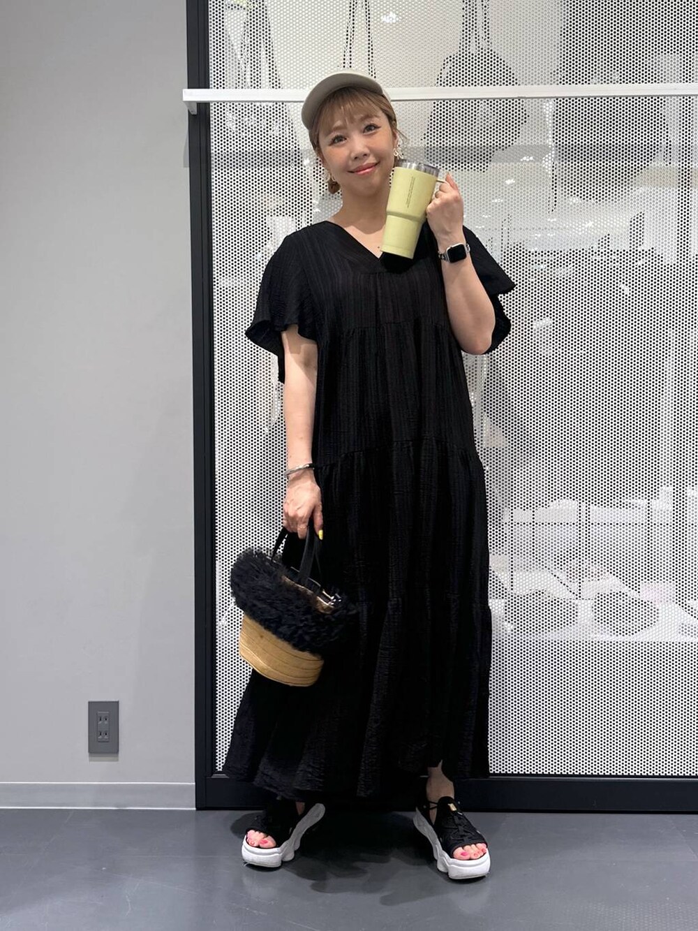 ベージュ系のショルダーバッグ、ブラック系のワンピース、ブラック系のサンダルを着用したレディースの春コーディネートの2枚目の写真