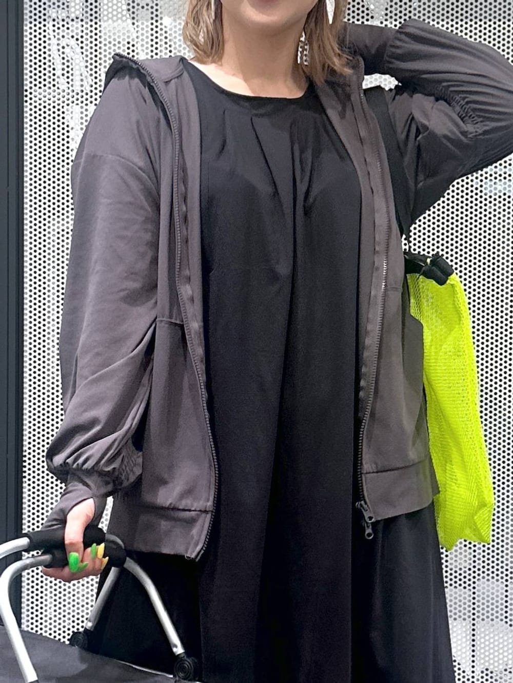 ブラック系のワンピース、イエロー系のトートバッグ、ホワイト系のサンダルを着用したレディースの春コーディネートの3枚目の写真