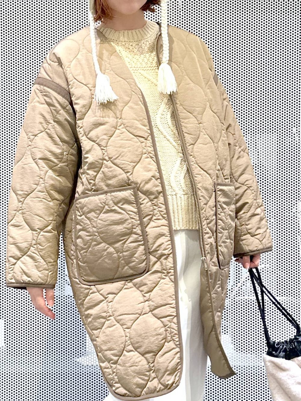 ブラウン系のスニーカー、ベージュ系のショルダーバッグ、グリーン系のナイロンジャケットを着用したレディースの冬コーディネートの7枚目の写真