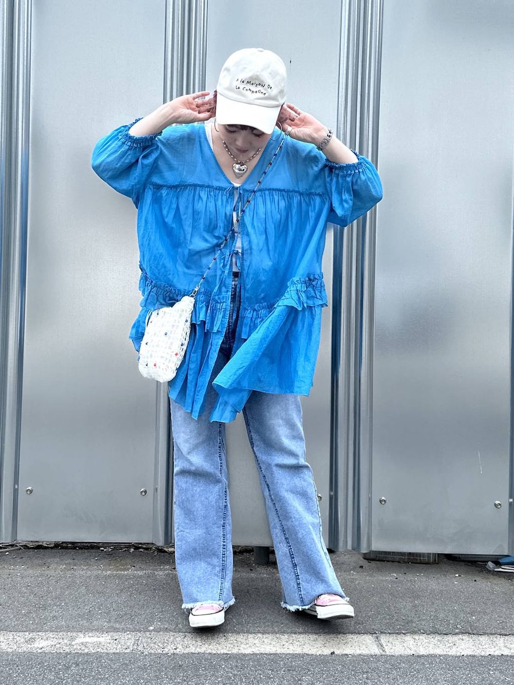 ブルー系のデニムパンツ、その他のショルダーバッグ、その他のピアス（両耳用）を着用したレディースの春コーディネートの2枚目の写真