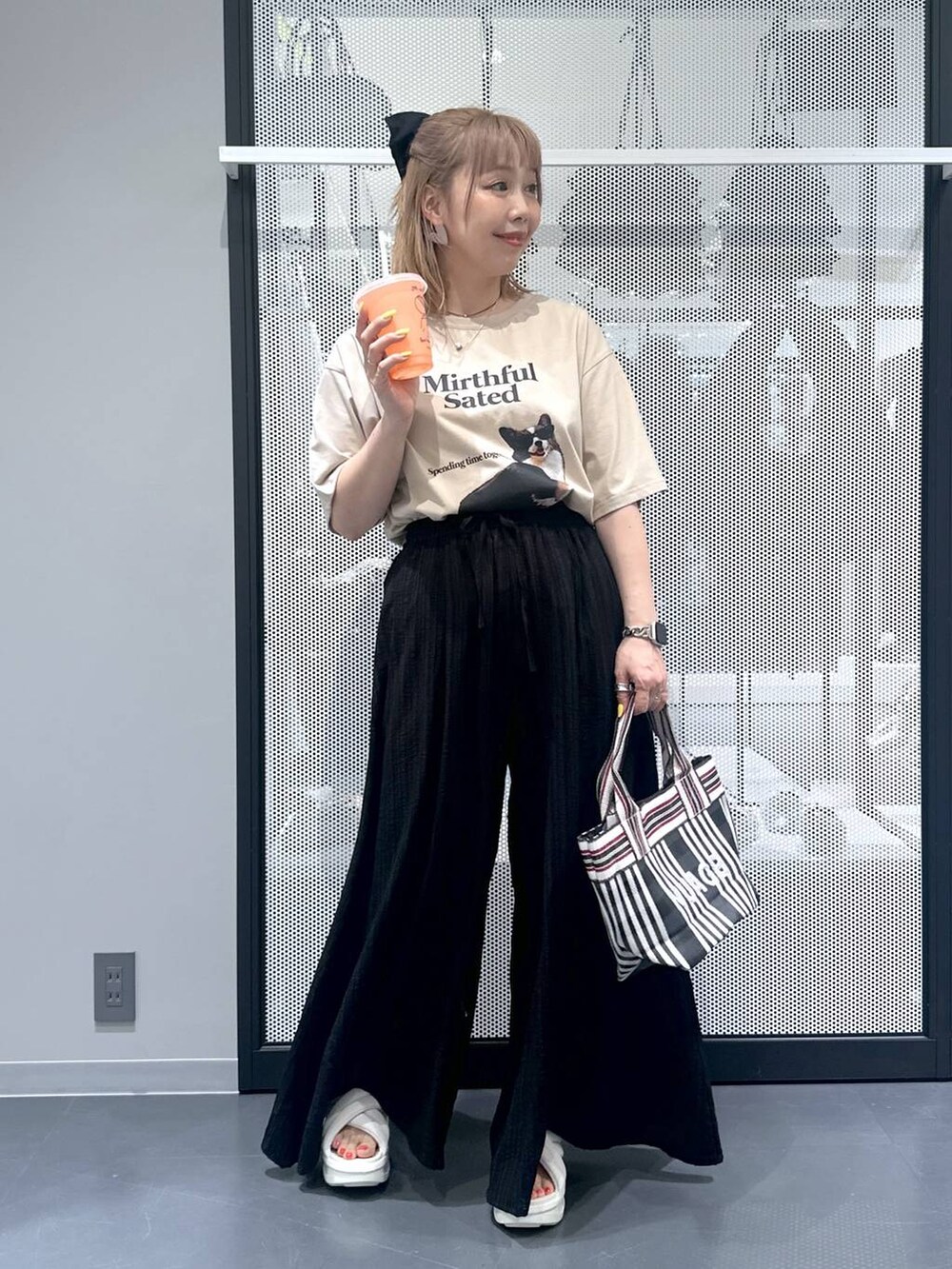 ブラック系のトートバッグ、ブラック系のその他パンツ、ベージュ系のTシャツ/カットソーを着用したレディースの春コーディネートの2枚目の写真