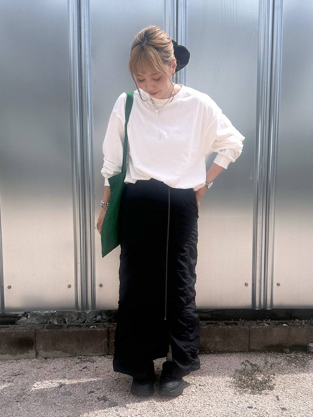 ブラック系のスカート、グリーン系のトートバッグ、その他のピアス(両耳用)を着用したレディースの秋コーディネートの3枚目の写真