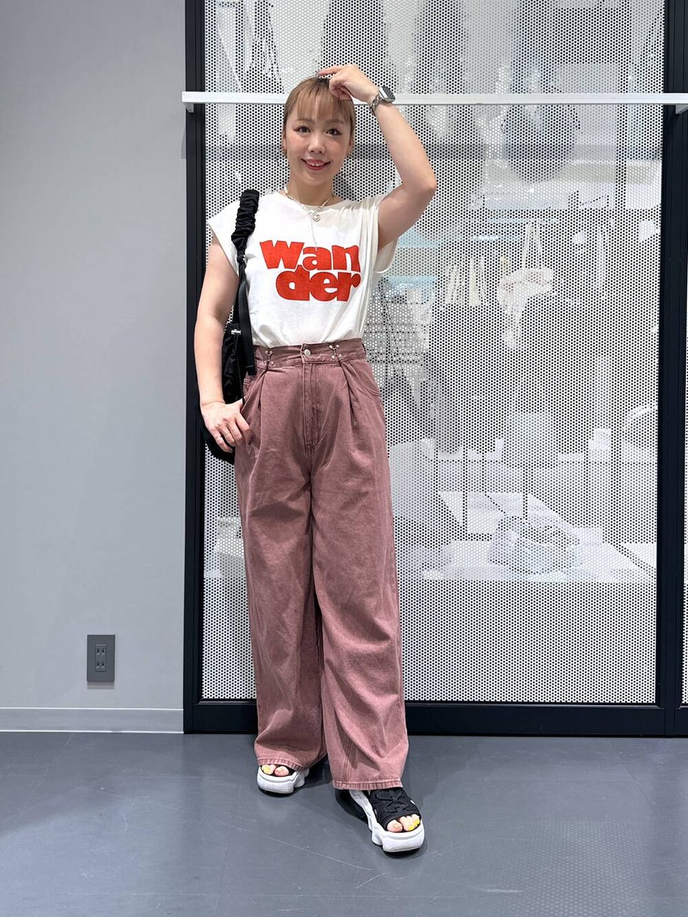 ブラック系のショルダーバッグ、ホワイト系のTシャツ/カットソー、ブラウン系のデニムパンツを着用したレディースの夏コーディネートの2枚目の写真