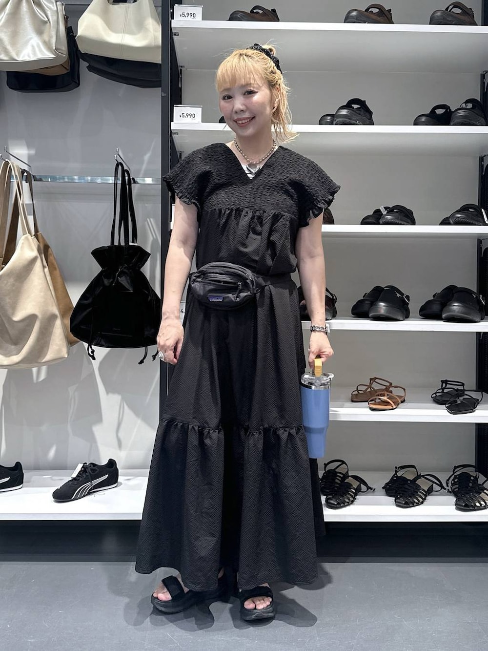 ブラック系のワンピース、シルバー系のデジタル腕時計、オレンジ系の水筒を着用したレディースの夏コーディネートの2枚目の写真