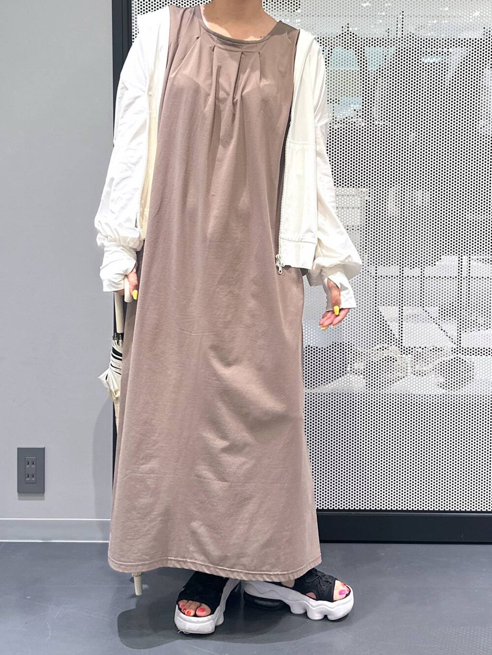 ブラウン系のワンピース、ブラック系のサンダル、ベージュ系の長傘を着用したレディースの春コーディネートの6枚目の写真