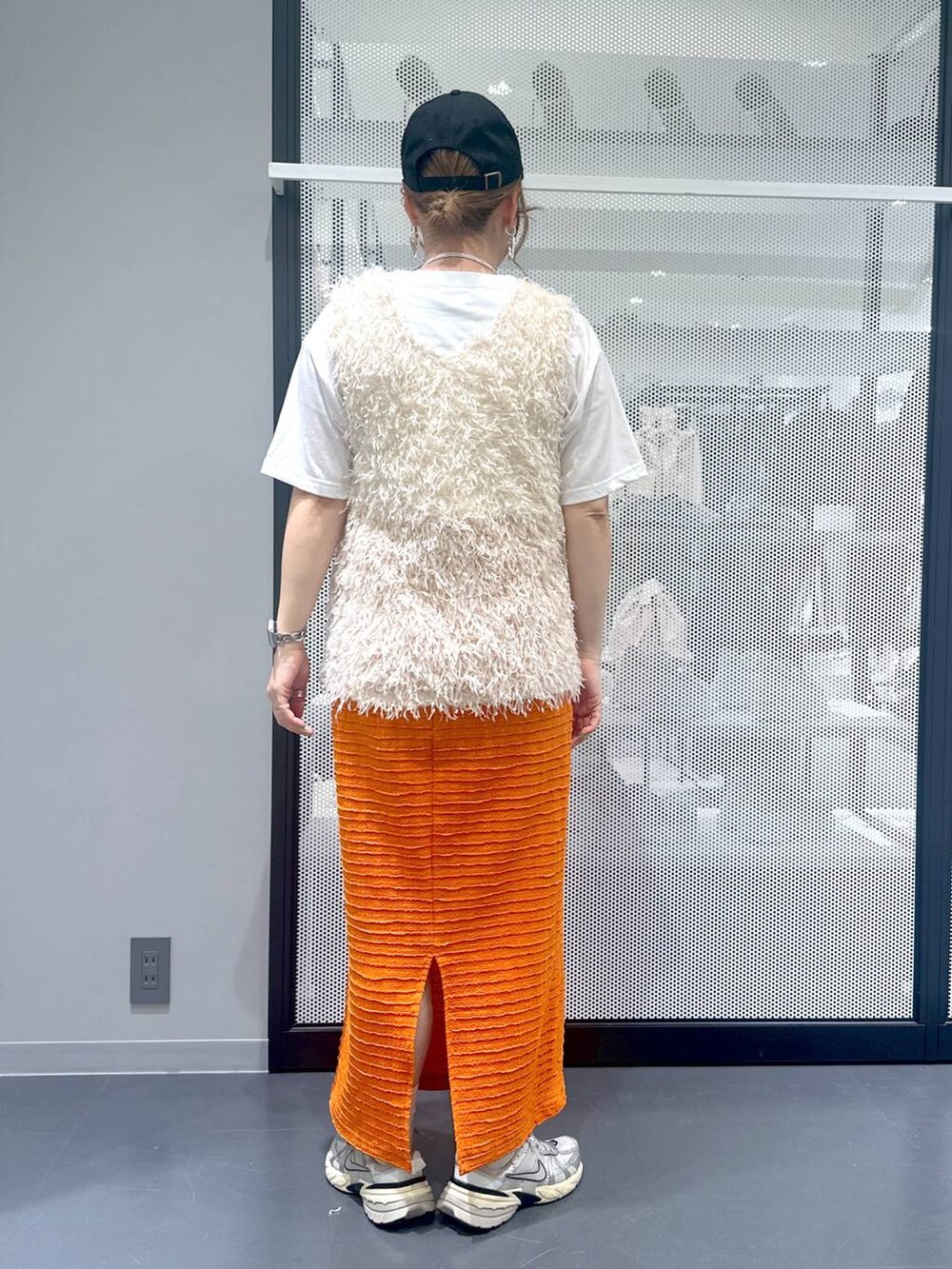 ブラック系のショルダーバッグ、ホワイト系のベスト、ホワイト系のTシャツ/カットソーを着用したレディースの春コーディネートの3枚目の写真