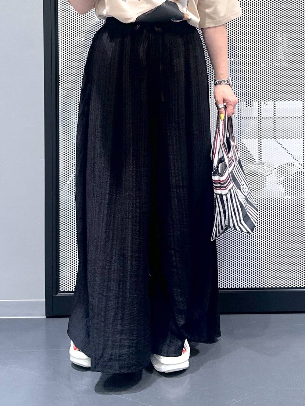 ブラック系のトートバッグ、ブラック系のその他パンツ、ベージュ系のTシャツ/カットソーを着用したレディースの春コーディネートの5枚目の写真