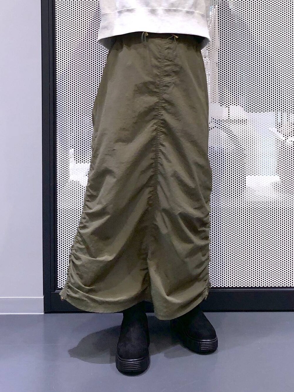 ブラック系のバックパック/リュック、グリーン系のスカート、ブラック系のベストを着用したレディースの冬コーディネートの5枚目の写真