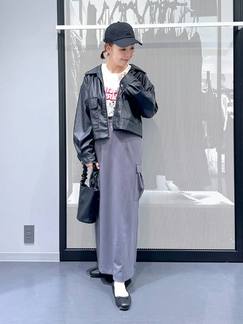 ブラック系のショルダーバッグ、ブラック系のブルゾン、ホワイト系のTシャツ/カットソーを着用したレディースの春コーディネートの7枚目の写真