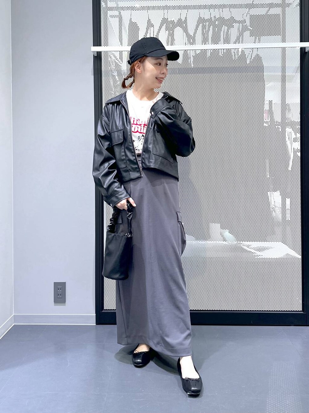 ブラック系のショルダーバッグ、ブラック系のブルゾン、ホワイト系のTシャツ/カットソーを着用したレディースの春コーディネートの2枚目の写真