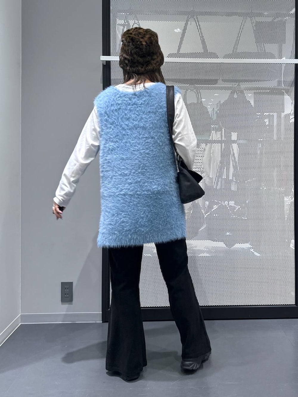 ブラック系のショルダーバッグ、ブルー系のベスト、ホワイト系のTシャツ/カットソーを着用したレディースの秋コーディネートの3枚目の写真