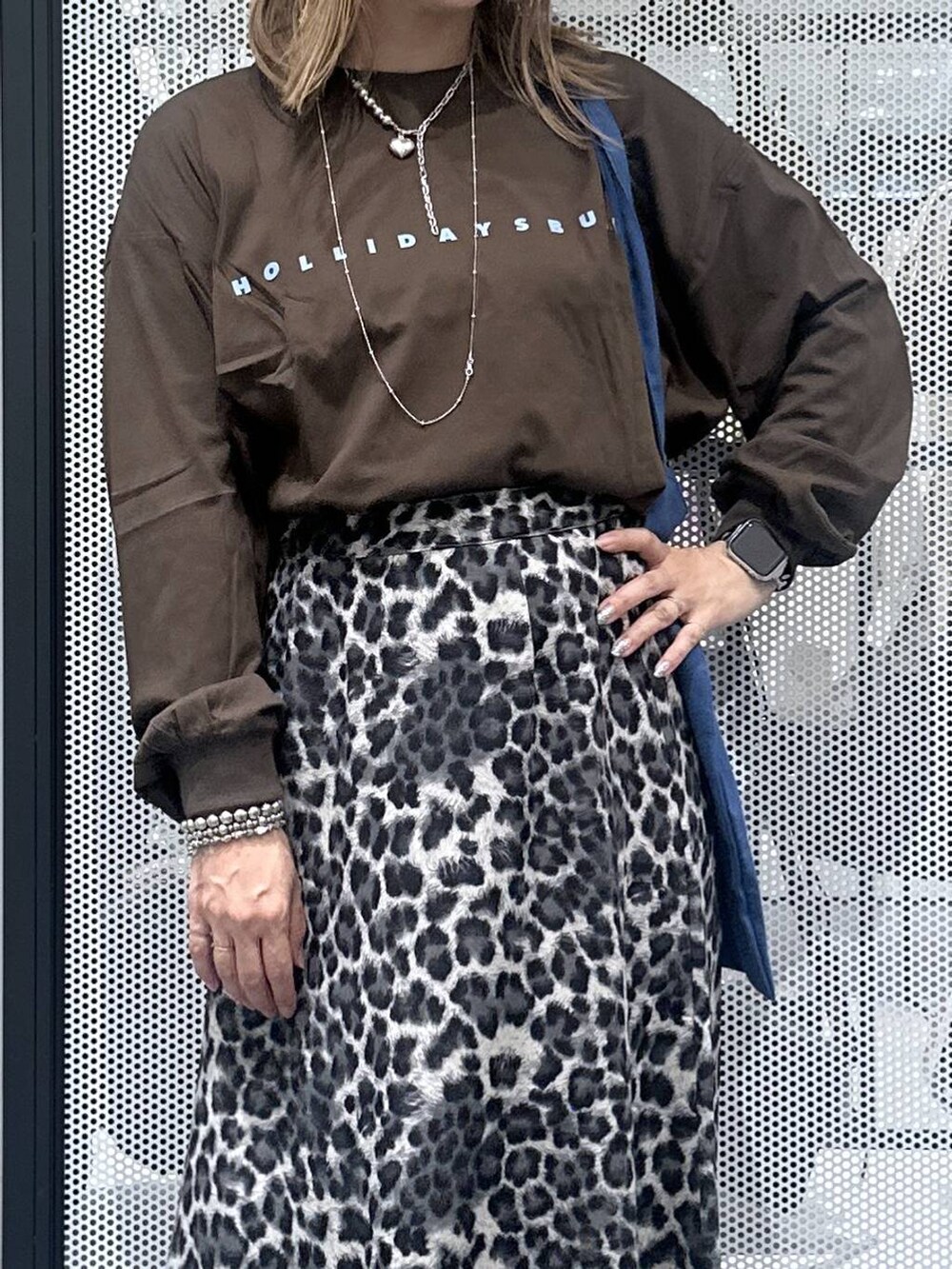 グレー系のスカート、その他のピアス（両耳用）、シルバー系のデジタル腕時計を着用したレディースの秋コーディネートの3枚目の写真