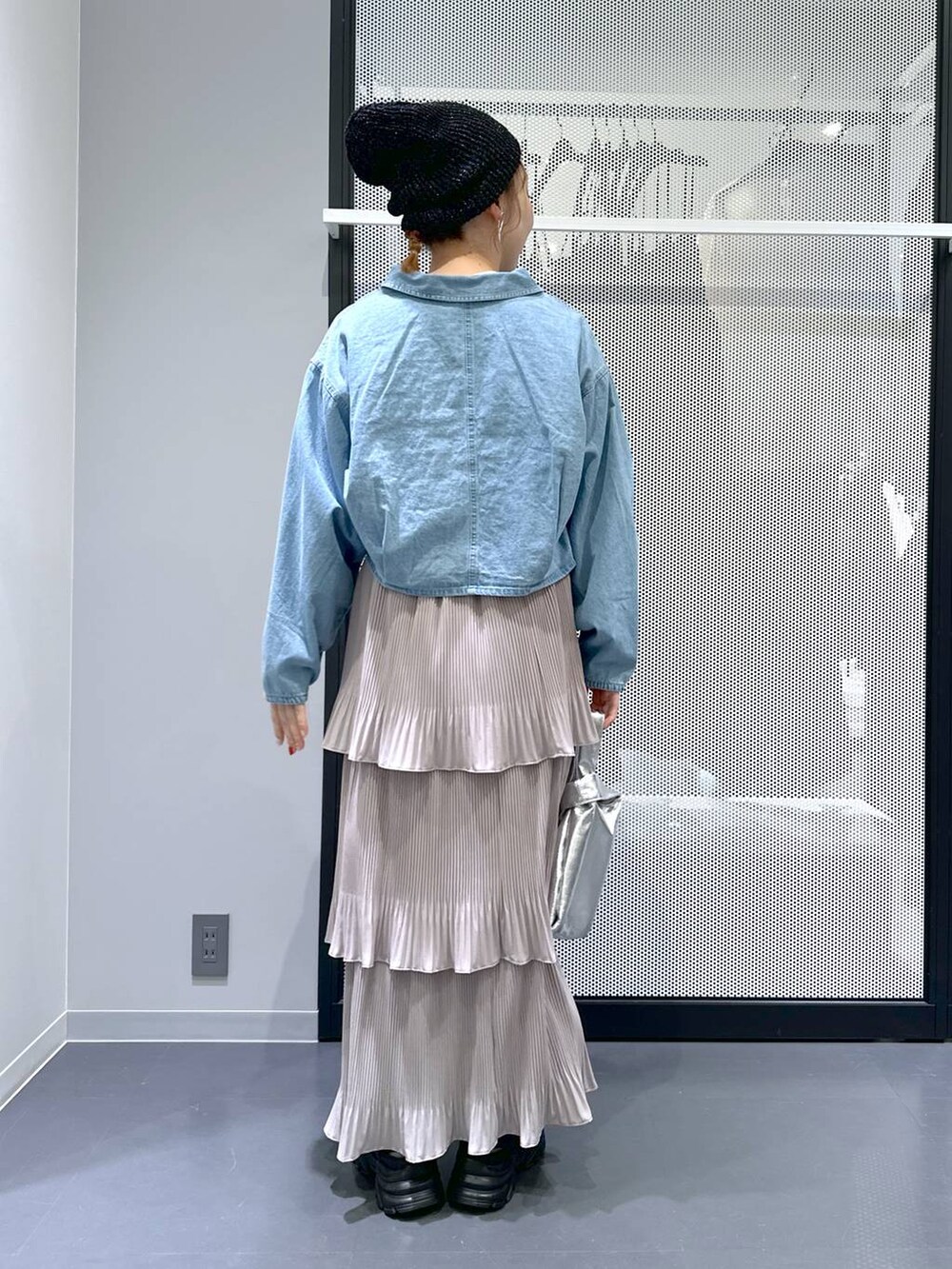 ブラック系のスニーカー、ブルー系のデニムジャケット、シルバー系のショルダーバッグを着用したレディースの春コーディネートの4枚目の写真