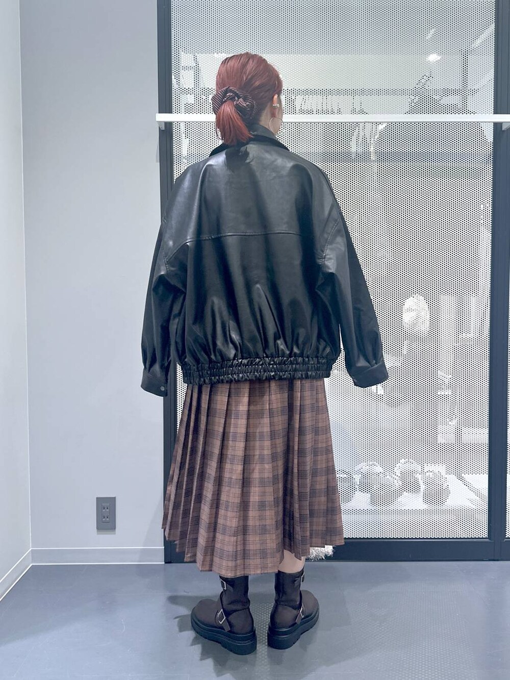 ホワイト系のショルダーバッグ、ブラック系のブルゾン、ブラウン系のブーツを着用したレディースの秋コーディネートの5枚目の写真