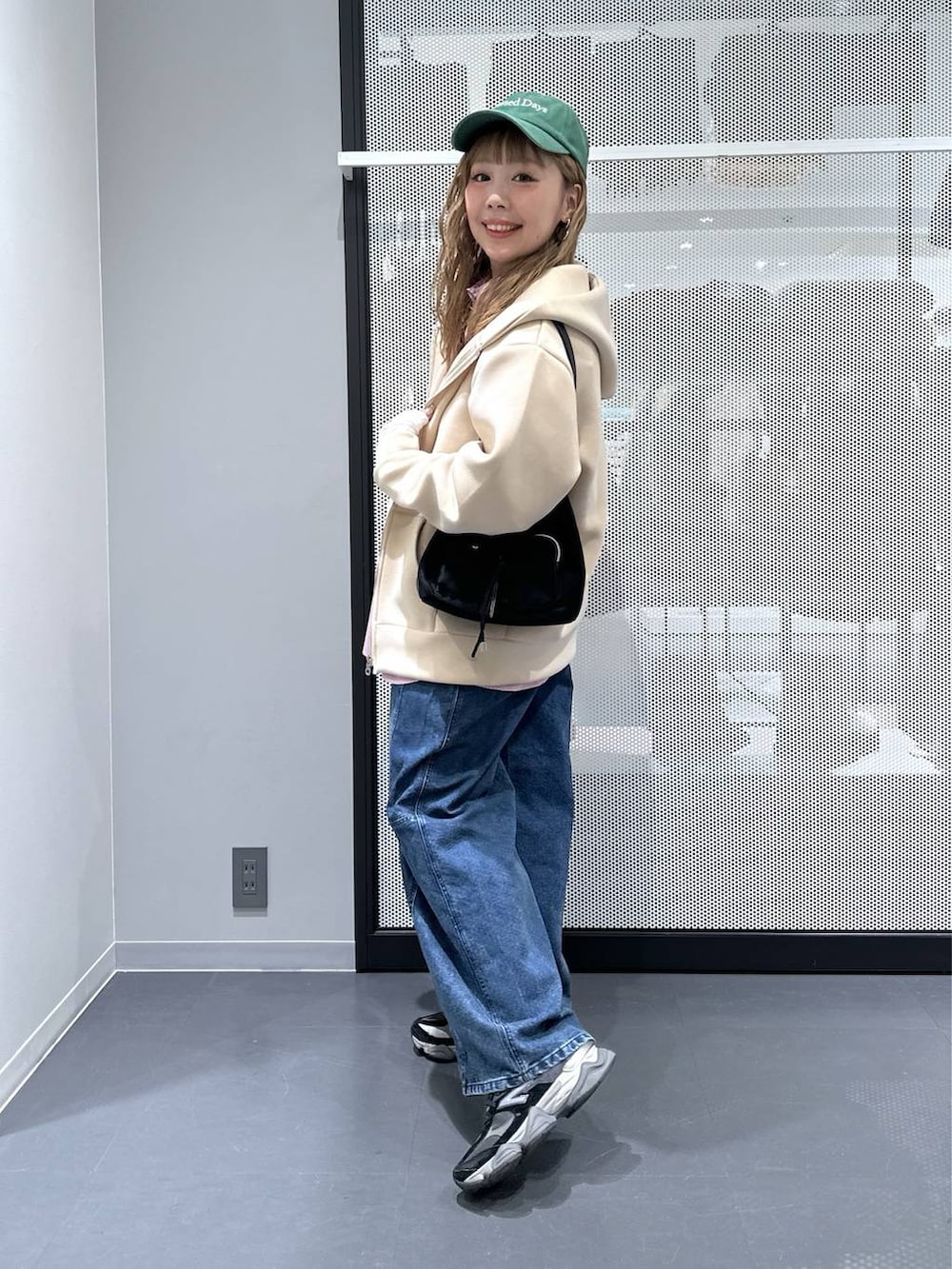 ホワイト系のTシャツ/カットソー、ブラック系のショルダーバッグ、ブルー系のデニムパンツを着用したレディースの冬コーディネートの4枚目の写真