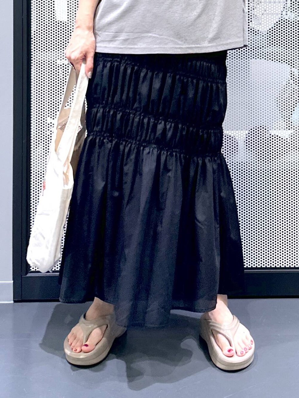 ホワイト系のベスト、ブラック系のスカート、その他のエコバッグ/サブバッグを着用したレディースの夏コーディネートの6枚目の写真