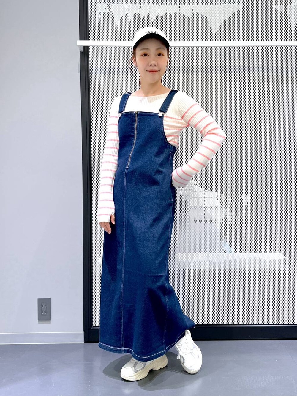 ブルー系のジャンパースカート、ベージュ系のMA-1、ピンク系のニット/セーターを着用したレディースの春コーディネートの5枚目の写真