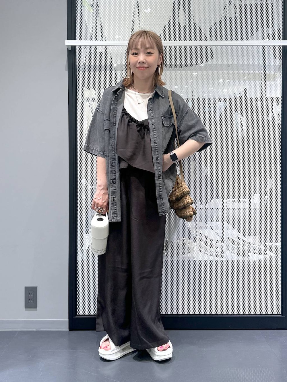 ベージュ系のショルダーバッグ、ブラック系のシャツ/ブラウス、ブラック系のつなぎ/オールインワンを着用したレディースの春コーディネートの2枚目の写真