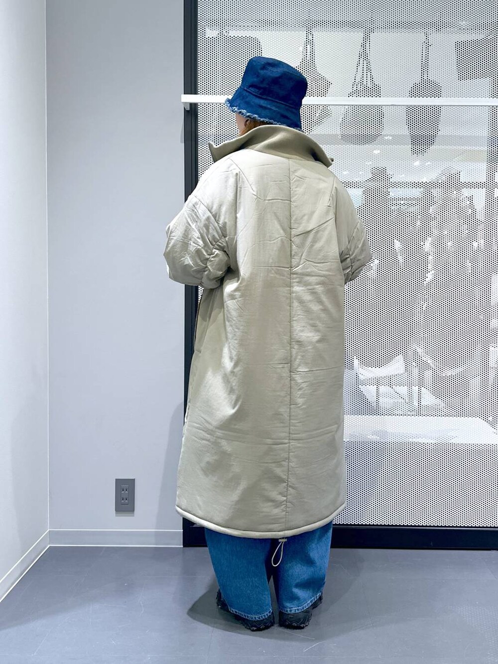 グレー系のスニーカー、ブルー系のデニムパンツ、グリーン系のミリタリージャケットを着用したレディースの冬コーディネートの5枚目の写真