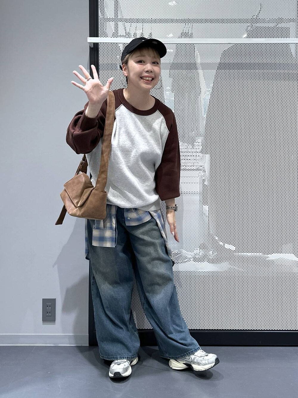 イエロー系のショルダーバッグ、ブルー系のデニムパンツ、ブラウン系のニット/セーターを着用したレディースの秋コーディネートの2枚目の写真