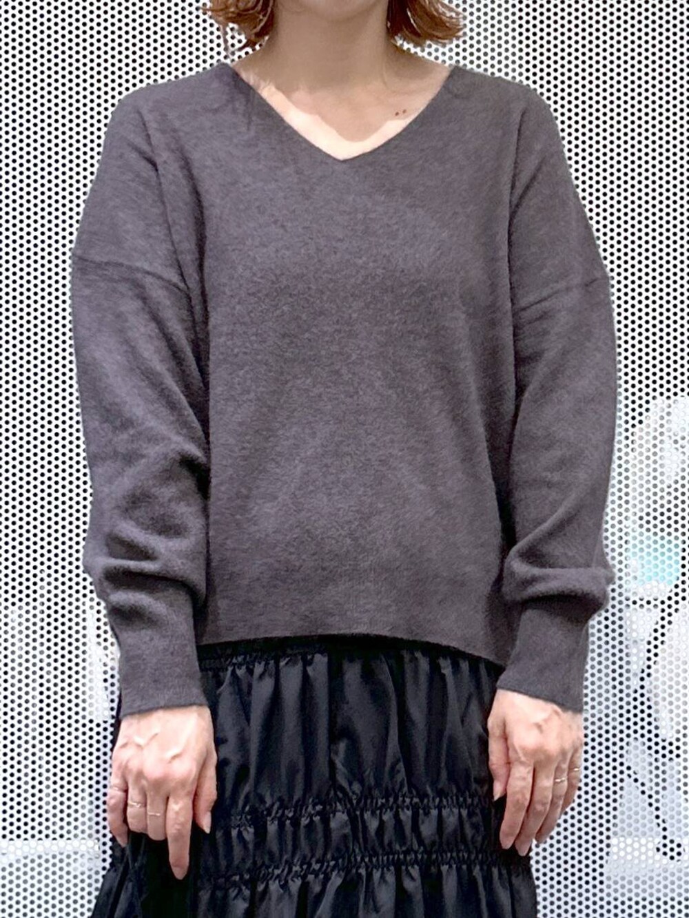 グレー系のニット/セーター、ブラック系のナイロンジャケット、ベージュ系のショルダーバッグを着用したレディースの冬コーディネートの5枚目の写真