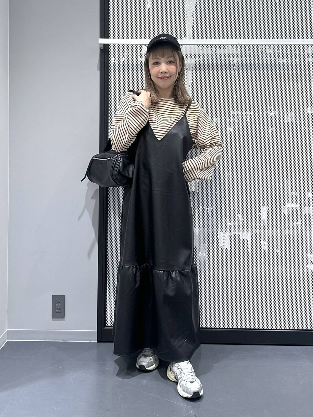 ブラウン系のパーカー、その他のピアス(両耳用)、ブルー系のキャップを着用したレディースの秋コーディネートの3枚目の写真