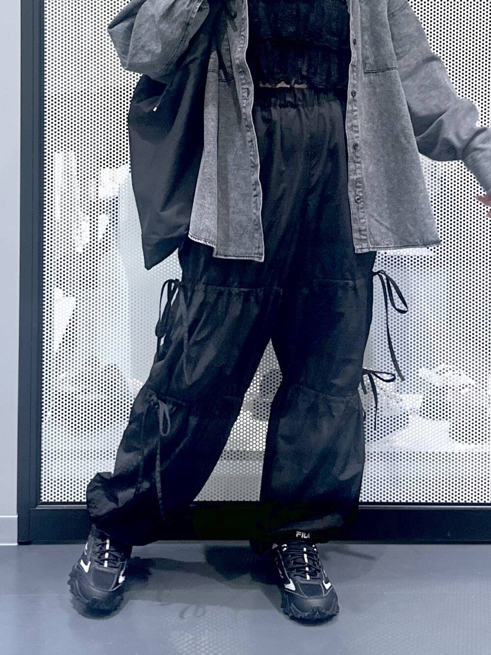 グレー系のスニーカー、ブラック系のショルダーバッグ、ブラック系のその他パンツを着用したレディースの秋コーディネートの6枚目の写真